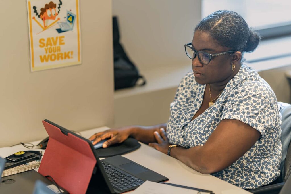 image of a black woman studying with an open computer